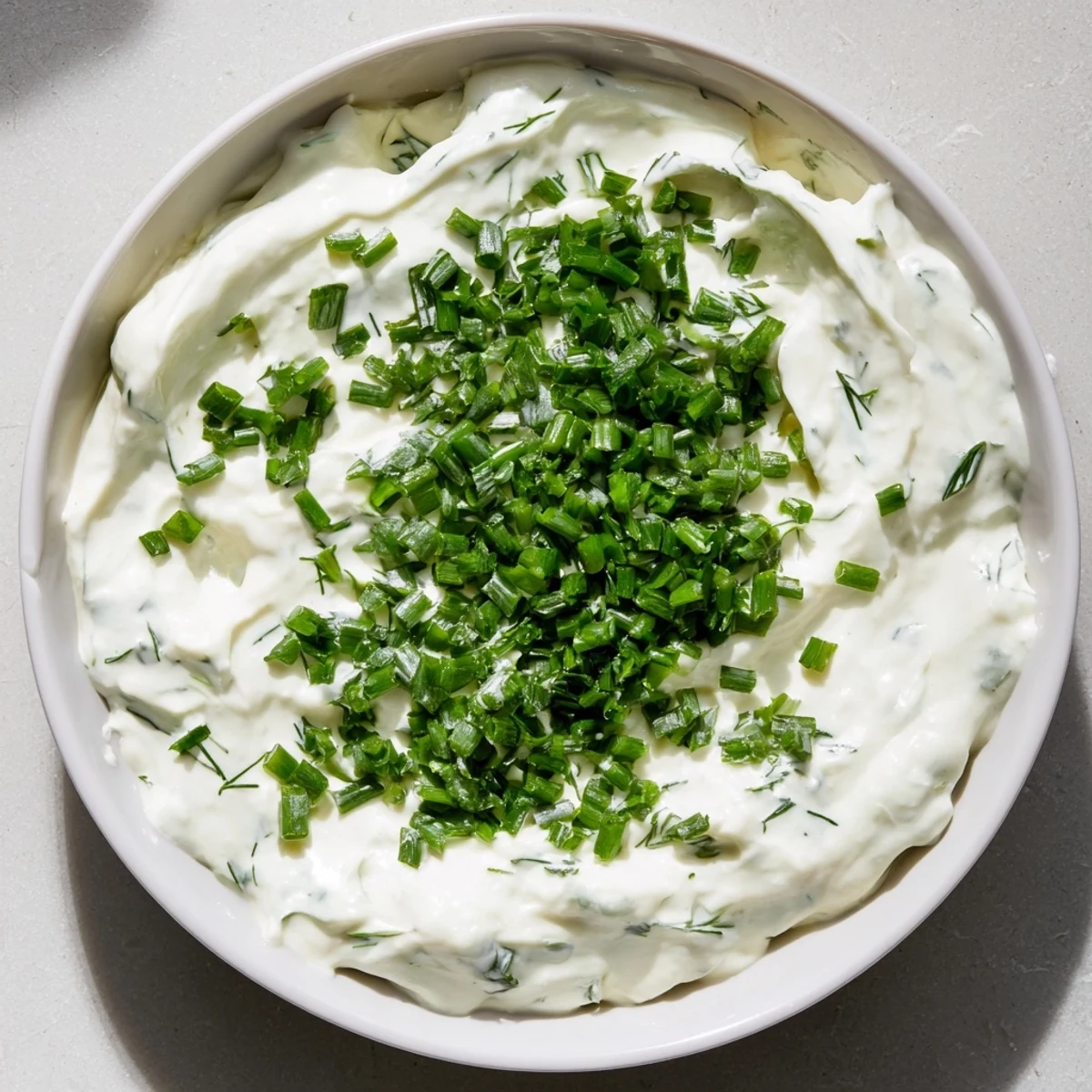 A creamy Veggie Ranch Dip with bright green chives, perfect with carrot sticks and cool veggies.