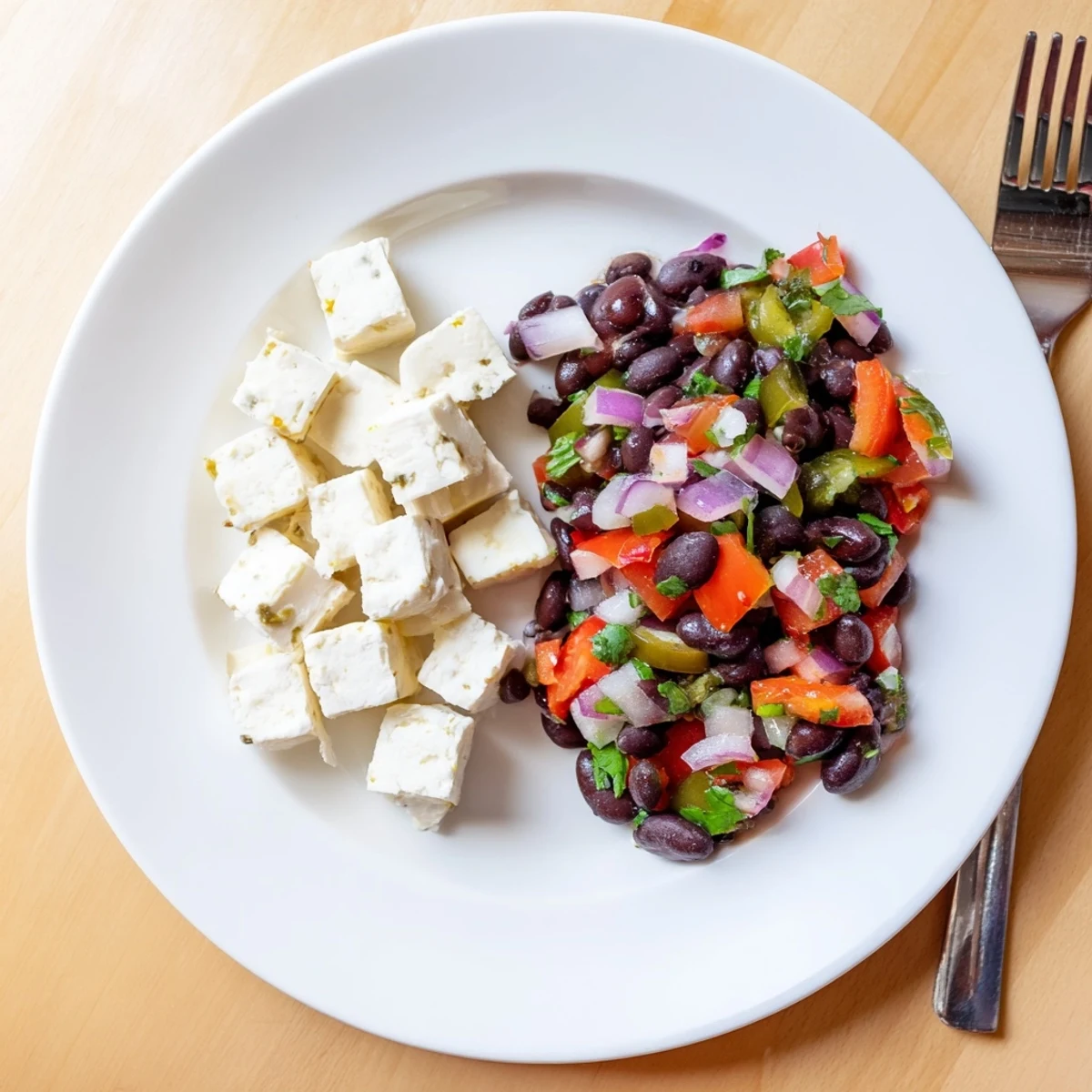 A close-up of savory Pepper Jack cubes next to zesty, flavorful black bean salsa, ideal for sharing.