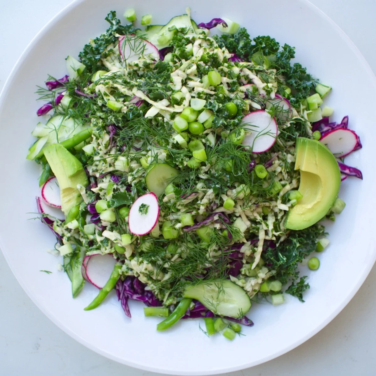 A colorful bowl of Green Goddess Detox Cabbage Salad with fresh herbs and a bright dressing.
