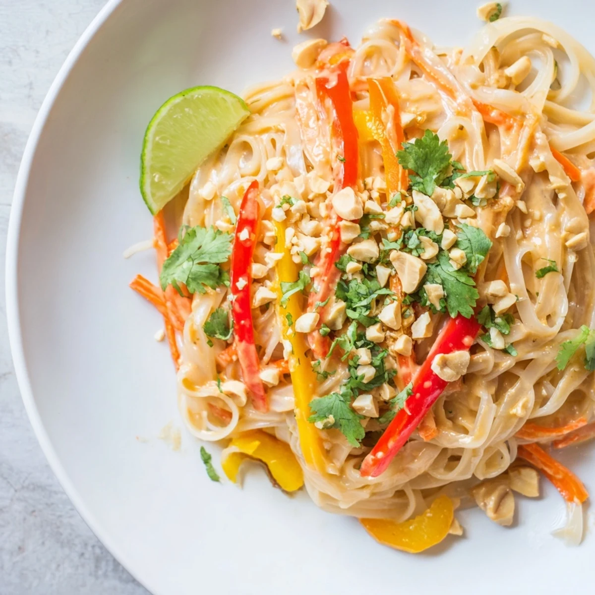 Steaming bowl of Spicy Peanut Noodles with colorful veggies, ready for a delicious, savory dinner.