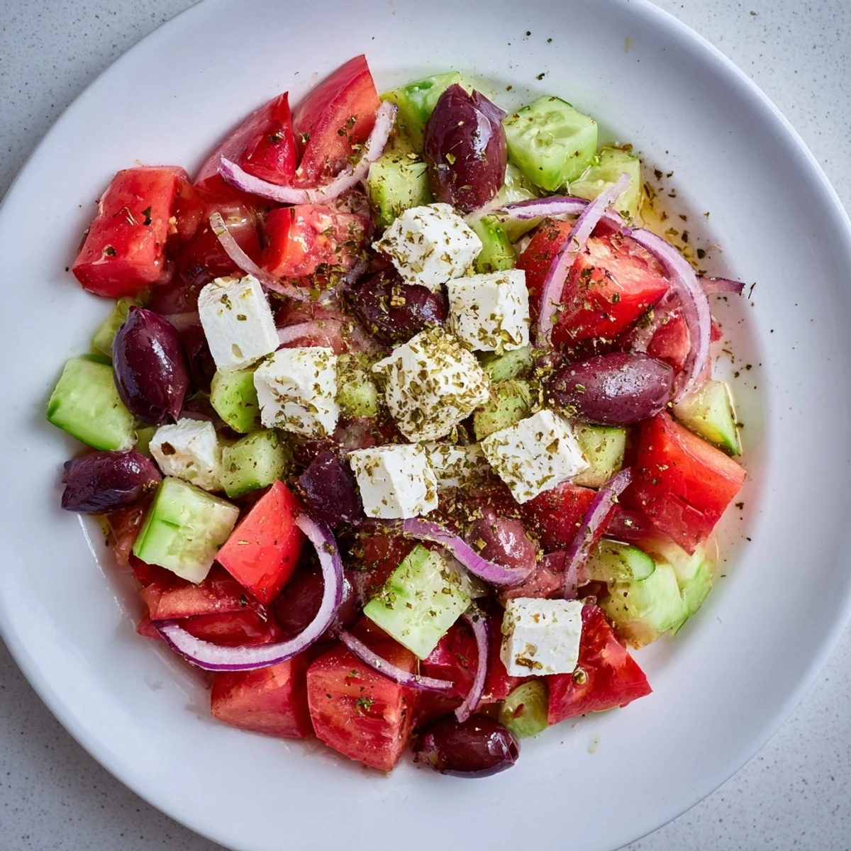 Brightly colored Mediterranean Salad: a flavorful mix of olives, crisp veggies, and feta drizzled with olive oil.