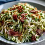 A vibrant German Cabbage Coleslaw with Shredded Ham garnished with fresh parsley, perfect as a gluten-free picnic side dish.