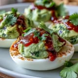 Vibrant green avocado filling transforms classic deviled eggs into a healthy, party-ready appetizer with a Sriracha kick.