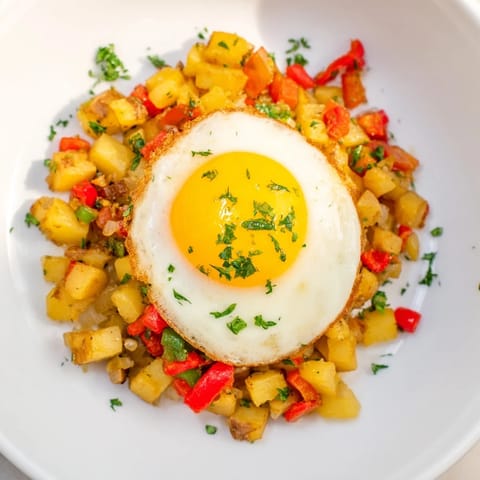 Golden potatoes and vibrant vegetables star in this easy simple skillet egg and potato hash recipe.