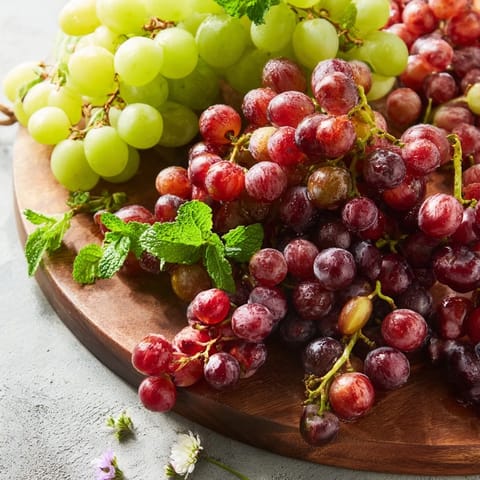 Juicy red and green grapes cascading beautifully over an edge; a simple grape appetizer.