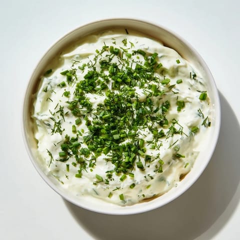 Freshly made Veggie Ranch Dip boasting a medley of herbs, ready for dipping on a platter.