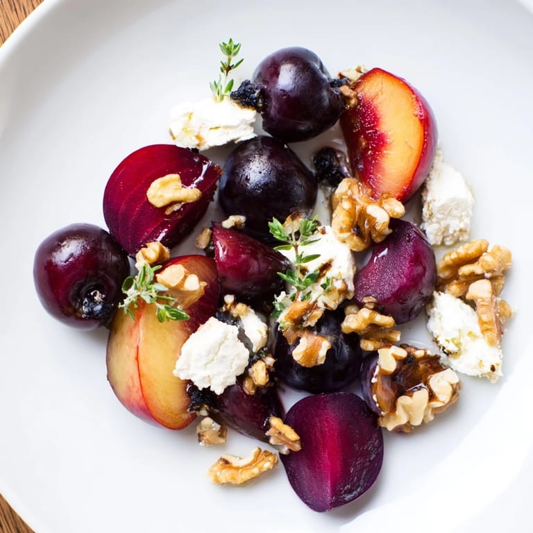 Sophisticated The Midnight Orchard appetizer: a vibrant, layered arrangement of fruit and ash-covered goat cheese.