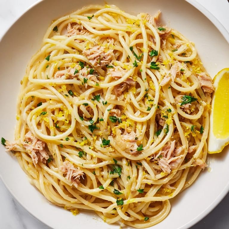 Close-up of steaming Lemon-Garlic Tuna Spaghetti, ready to enjoy with a burst of fresh parsley.