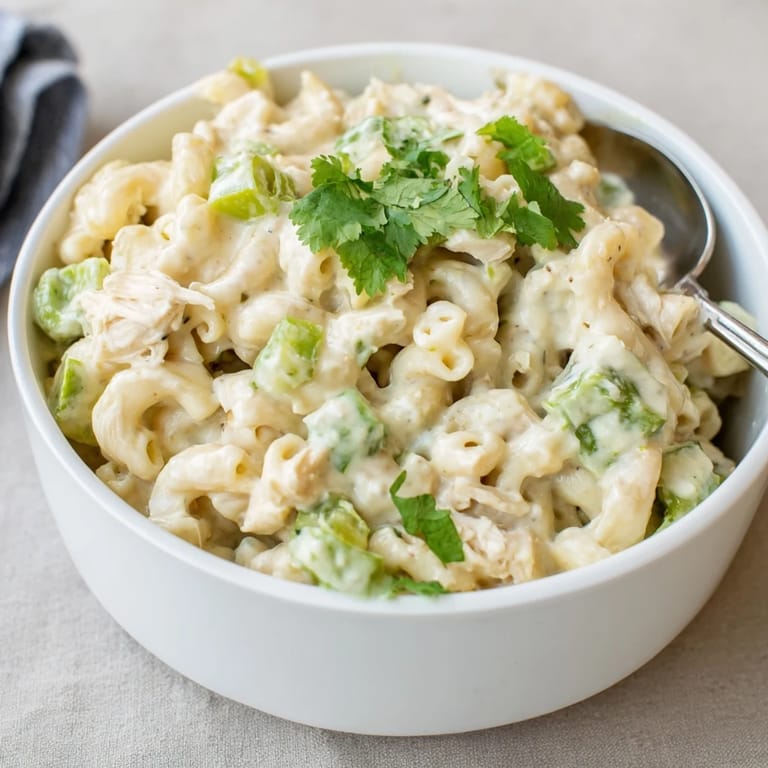 An overhead view of Green Chili Chicken Mac, showing the golden cheese crust and specks of mild green chiles.