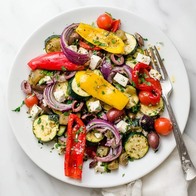 Caramelized red onion, eggplant, and tomatoes mingle with cool cucumber in this zesty Roasted Greek Salad served with lemon-oregano dressing.