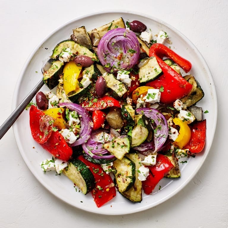 A platter of golden roasted vegetables topped with crumbled feta and Kalamata olives makes a hearty, vegetarian Roasted Greek Salad.